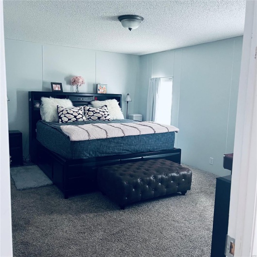 Carpeted bedroom featuring a textured ceiling