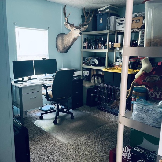 Home office featuring a textured ceiling and speckle patterned floor