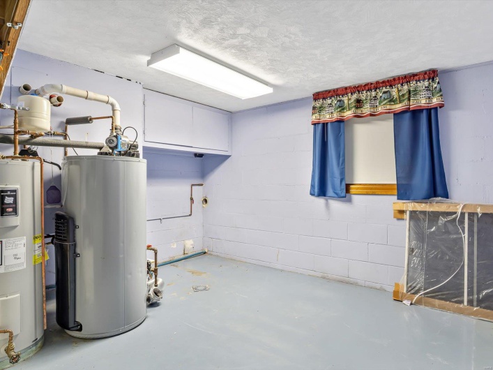 Utility room featuring gas water heater and water heater