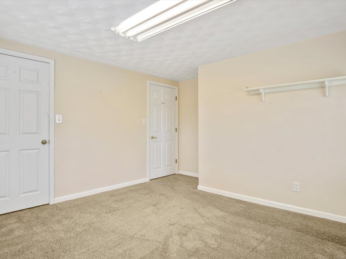 Carpeted spare room featuring baseboards and a textured ceiling