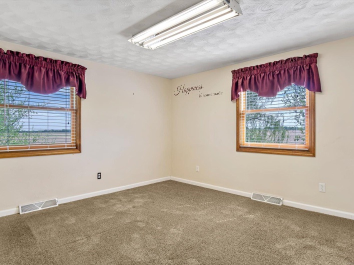 Carpeted spare room with baseboards and a textured ceiling