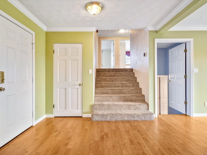 Staircase featuring wood finished floors, crown molding, and baseboards