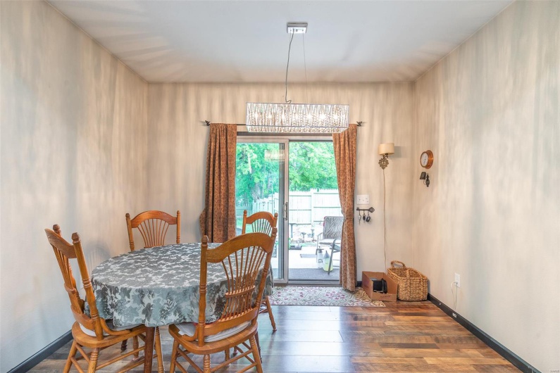Dining space featuring wood finished floors, a chandelier, and baseboards