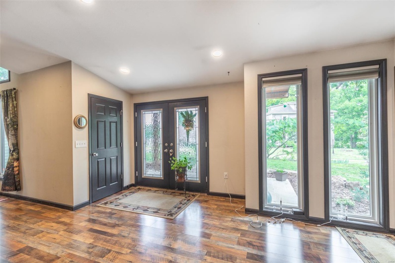 Entryway with wood finished floors, baseboards, recessed lighting, and lofted ceiling