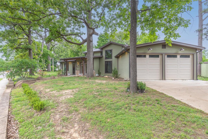 View of front of home featuring driveway, an attached garage, and a front lawn