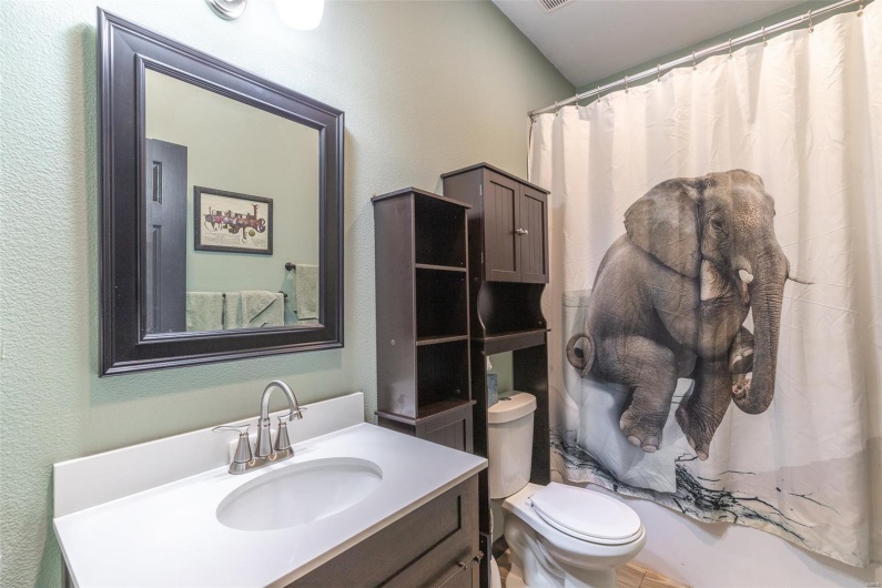 Full bathroom with a textured wall, toilet, and vanity