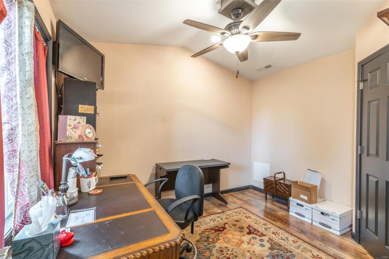 Office area featuring wood finished floors, ceiling fan, and lofted ceiling
