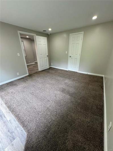 Empty room featuring recessed lighting, baseboards, and dark colored carpet