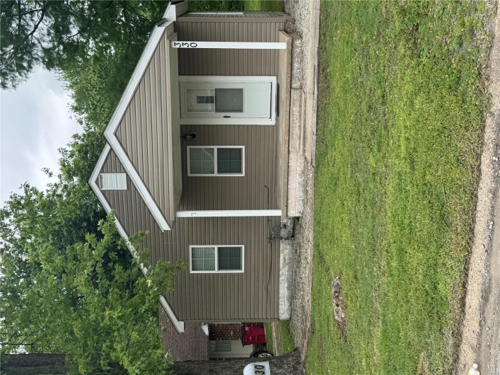 View of front of home featuring covered porch and a front yard