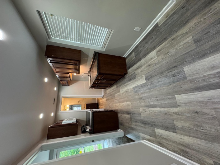 Kitchen featuring dark countertops, wood finished floors, recessed lighting, dark brown cabinetry, and baseboards