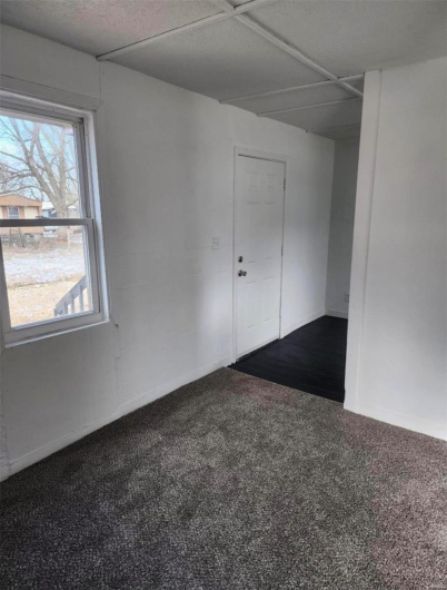 Spare room with dark colored carpet