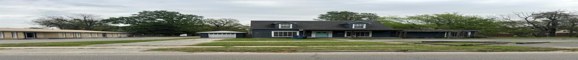 Residential For Sale View of front of house featuring asphalt driveway, a porch, a garage, an outdoor structure, and a front yard