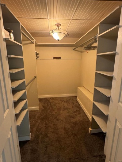 Walk in closet with dark carpet